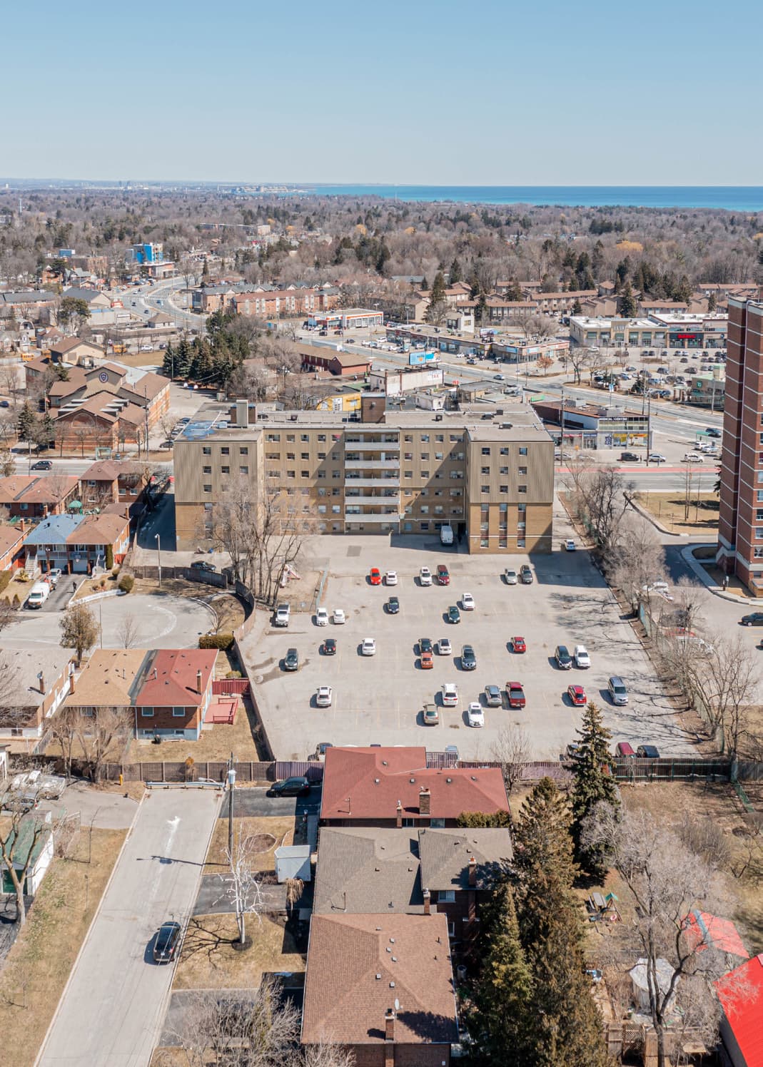 Aerial view of the 290 Morningside site showing the surface parking lot behind the building and Lake Ontario beyond